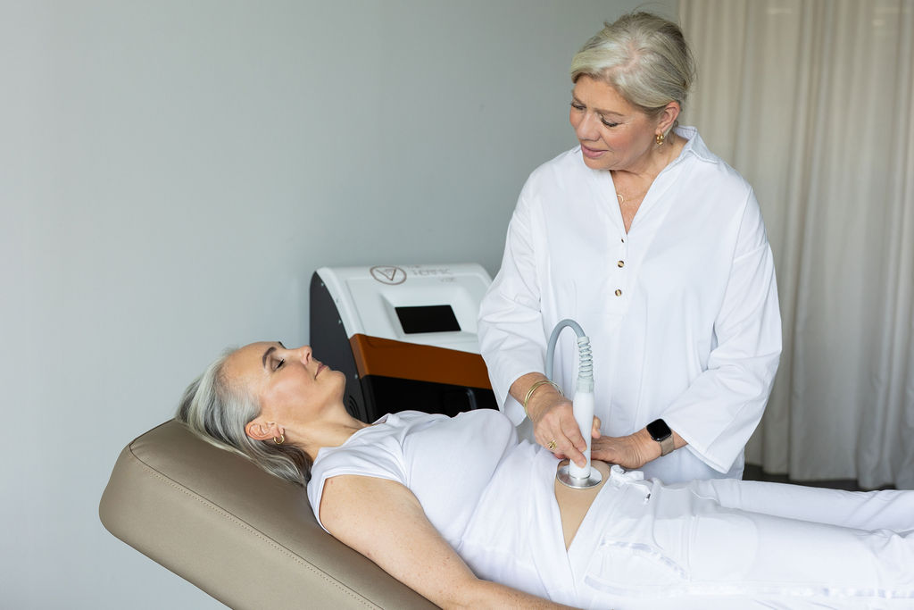 Vibra-behandeling op de buik door een professional in een beautypraktijk
